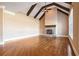 Bright living room with vaulted ceiling, exposed beams, stone fireplace, and gleaming hardwood floors at 2602 Alcovy Club Dr, Dacula, GA 30019