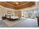 Spacious main bedroom featuring a tray ceiling, sitting area and neutral decor at 2602 Alcovy Club Dr, Dacula, GA 30019