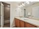 Bathroom with wood cabinets, a light countertop, a large mirror, decorative lighting, and a shower/tub combo at 3901 Old Atlanta Station Se Dr, Atlanta, GA 30339