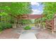 Wood pergola with stone base sits within a grassy area amongst mature trees and a wooden fence at 3901 Old Atlanta Station Se Dr, Atlanta, GA 30339