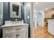 Stylish powder room with a marble vanity, decorative mirror, and adjacent hallway views at 3901 Old Atlanta Station Se Dr, Atlanta, GA 30339