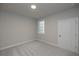 Cozy bedroom featuring neutral carpet, a large window, and a white door at 504 Winston Croft Cir # 54, Johns Creek, GA 30022