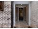 Elegant front door with glass panes and brickwork, complemented by white trim and a brick pathway at 504 Winston Croft Cir # 54, Johns Creek, GA 30022