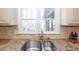 Double stainless steel sink with granite countertop and tile backsplash at 5412 Wild Flower Ct, Powder Springs, GA 30127