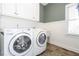 Bright laundry room featuring washer, dryer and cabinets at 5412 Wild Flower Ct, Powder Springs, GA 30127