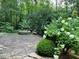 Stone patio with fire pit, surrounded by lush greenery at 5412 Wild Flower Ct, Powder Springs, GA 30127