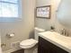 Small bathroom with a dark brown vanity and a round mirror at 3581 Drum Roll Ln, Snellville, GA 30039