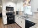 Modern kitchen with white cabinets, granite countertops, and black appliances at 3581 Drum Roll Ln, Snellville, GA 30039