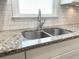 Modern kitchen sink with a pull-down faucet and granite countertops at 3581 Drum Roll Ln, Snellville, GA 30039