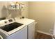 Bright laundry room with washer, dryer, and shelving at 3581 Drum Roll Ln, Snellville, GA 30039