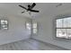 Bright bedroom featuring a ceiling fan, light gray floors, and three windows at 7650 Abbey Glen Dr, Cumming, GA 30028