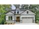 Charming two-story home with a two-car garage, stone accents, and a well-manicured front lawn at 7650 Abbey Glen Dr, Cumming, GA 30028