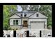 Beautiful two-story home with a two-car garage, stone accents, and a welcoming entrance at 7650 Abbey Glen Dr, Cumming, GA 30028