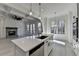 Spacious kitchen island with white cabinets and an archway to the living room with fireplace at 7650 Abbey Glen Dr, Cumming, GA 30028