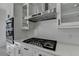Well-equipped kitchen featuring a gas range, stainless steel hood, and sleek white cabinetry at 7650 Abbey Glen Dr, Cumming, GA 30028