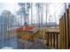 Wooden deck overlooks a wooded area with a partial view of buildings in the distance at 740 Abbotts Mill Ct, Johns Creek, GA 30097