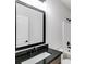Bathroom with dark vanity, white sink, and black framed mirror at 458 Florence Rd, Douglasville, GA 30134
