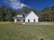 White farmhouse style home with landscaped lawn at 458 Florence Rd, Douglasville, GA 30134