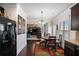 Cozy dining area with dark wood floors, a modern chandelier, and views into the adjacent living area at 520 Harmony Way, Locust Grove, GA 30248