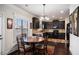 Bright dining area adjacent to the kitchen, featuring dark wood floors, an elegant chandelier and a window view at 520 Harmony Way, Locust Grove, GA 30248