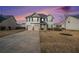 Charming two-story home with a two car garage, manicured landscaping, and a concrete driveway at dusk at 520 Harmony Way, Locust Grove, GA 30248