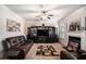 Spacious living room features a fireplace, built-in shelving, a ceiling fan and a comfortable leather sofa at 520 Harmony Way, Locust Grove, GA 30248