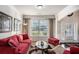 Bright living room showcasing a plush red sofa, decorative artwork, and natural light streaming through large windows at 520 Harmony Way, Locust Grove, GA 30248