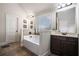 Relaxing bathroom with a large soaking tub, vanity, and ample natural light from the window at 520 Harmony Way, Locust Grove, GA 30248