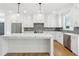 Bright kitchen with white cabinets, a marble island, stainless appliances, and wood floors at 116 Cottage Gate Ln, Roswell, GA 30076