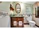 Charming bathroom with wood vanity, green walls and floral accents at 305 Carrolls Way, Fayetteville, GA 30215