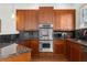 Modern kitchen with double oven, granite countertops, and wood cabinets at 821 Edgewood Ave # A, Atlanta, GA 30307