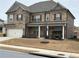 Two-story brick home with a large front porch and a three-car garage at 3566 Andover Way, Buford, GA 30519