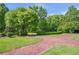 Well-maintained yard showcasing the verdant lawn, garden beds, and brick pathway at 5200 Moore Rd, Suwanee, GA 30024