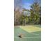 Outdoor basketball court with green playing surface, black fencing, and a basketball at the edge of the court at 5200 Moore Rd, Suwanee, GA 30024