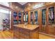 Spacious walk-in closet featuring custom wood cabinetry, glass doors, and ample storage space at 5200 Moore Rd, Suwanee, GA 30024