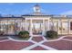 Open-air courtyard with white pillars, decorative lighting, manicured bushes, and patterned brick paving stones at 5200 Moore Rd, Suwanee, GA 30024