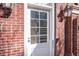 White front door with sidelights, flanked by brick walls and lanterns at 5200 Moore Rd, Suwanee, GA 30024