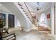 Grand foyer with curved staircase, stone flooring, and elegant lighting fixtures at 5200 Moore Rd, Suwanee, GA 30024
