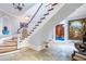 Elegant curved staircase, chandelier, and stone floors grace this home's foyer at 5200 Moore Rd, Suwanee, GA 30024