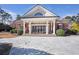 Grand home entrance featuring white columns and stone tiling under a triangular roof with intricate latticework above the front door at 5200 Moore Rd, Suwanee, GA 30024