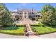 Majestic home featuring an elegant brick facade, grand staircase, and meticulously landscaped grounds at 5200 Moore Rd, Suwanee, GA 30024