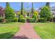 Impressive front yard with a grand circular driveway, lush lawn, and meticulously maintained landscaping at 5200 Moore Rd, Suwanee, GA 30024