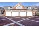 A three-car garage with a brick exterior, white doors, and a patterned brick driveway adds curb appeal at 5200 Moore Rd, Suwanee, GA 30024