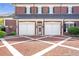 Well-maintained garages with brick facade and decorative lighting, complemented by a patterned brick driveway at 5200 Moore Rd, Suwanee, GA 30024