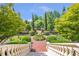 Beautifully landscaped garden with manicured hedges, brick pathways, and elegant stone railings at 5200 Moore Rd, Suwanee, GA 30024