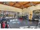 Home gym featuring wood-beamed ceilings, ceiling fans, workout equipment, and glass doors that look to the home's exterior at 5200 Moore Rd, Suwanee, GA 30024