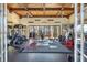 Spacious home gym with wood-beamed ceiling, multiple ceiling fans and an array of workout equipment framed by glass doors at 5200 Moore Rd, Suwanee, GA 30024
