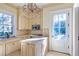 Bright butler's pantry with a charming chandelier, white cabinets, granite countertops, stainless steel appliances, and outside access at 5200 Moore Rd, Suwanee, GA 30024