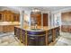 A huge kitchen island features granite countertops, dark cabinets, and custom fixtures at 5200 Moore Rd, Suwanee, GA 30024