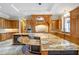 The large gourmet kitchen features custom wood cabinets and granite counter tops on a two-tiered island at 5200 Moore Rd, Suwanee, GA 30024